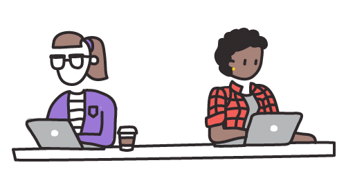 Two people working on laptops at a shared table, one wearing a purple jacket and one in a red plaid shirt