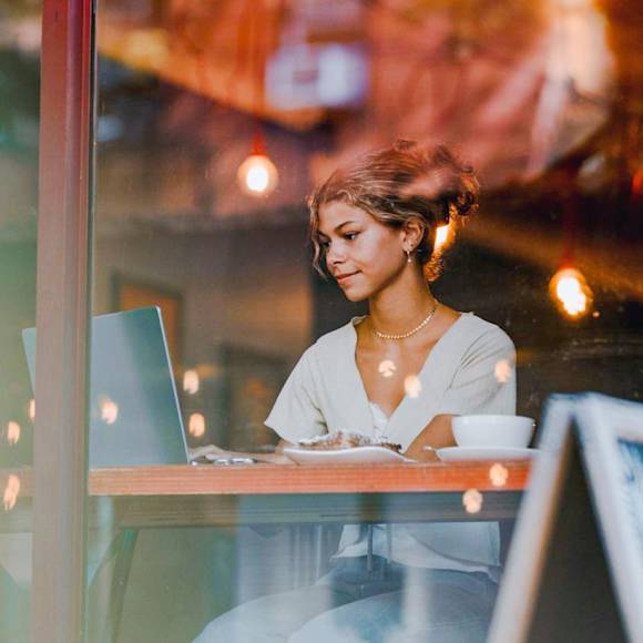 Woman in white shirt working in a cafe