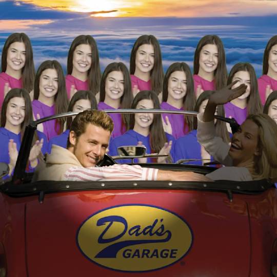 Two people in a red convertible with "Dad's Garage" logo, against backdrop of multiple identical figures in colorful hoodies at sunset