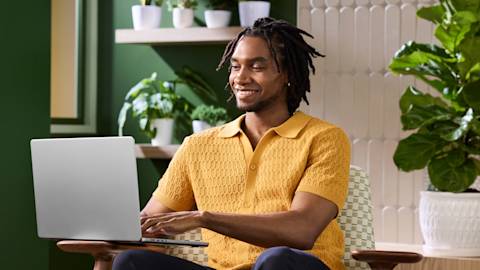Man in yellow shirt working on laptop