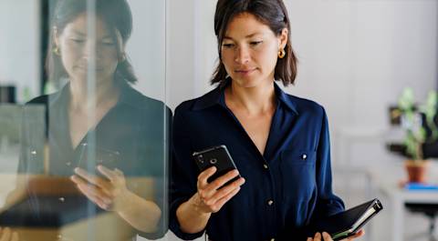 Woman in blue shirt, looking at phone