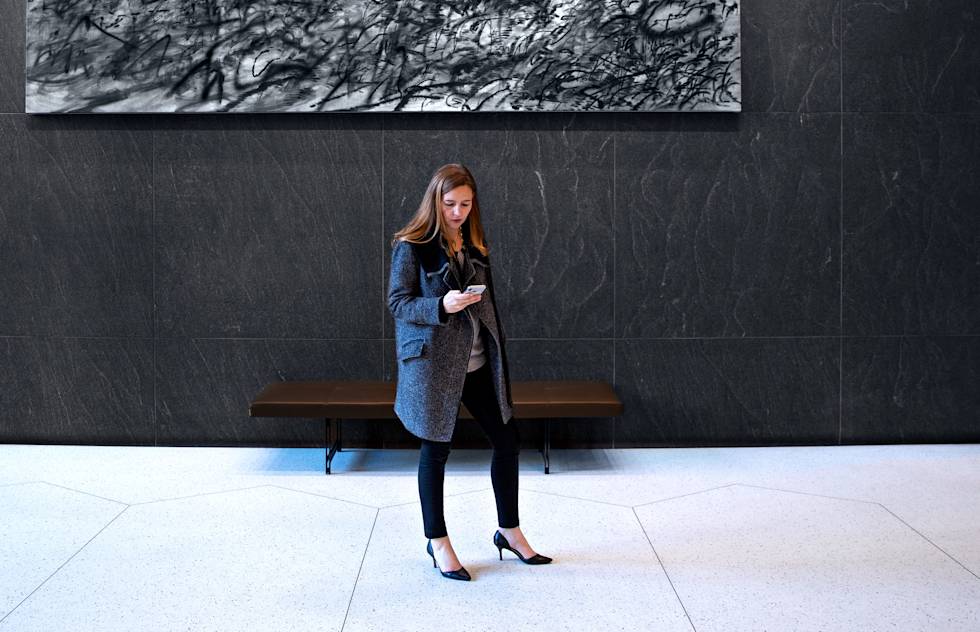 Image of UrbanSitter Co-Founder and Vice President of Marketing Daisy Downs looking at her phone 