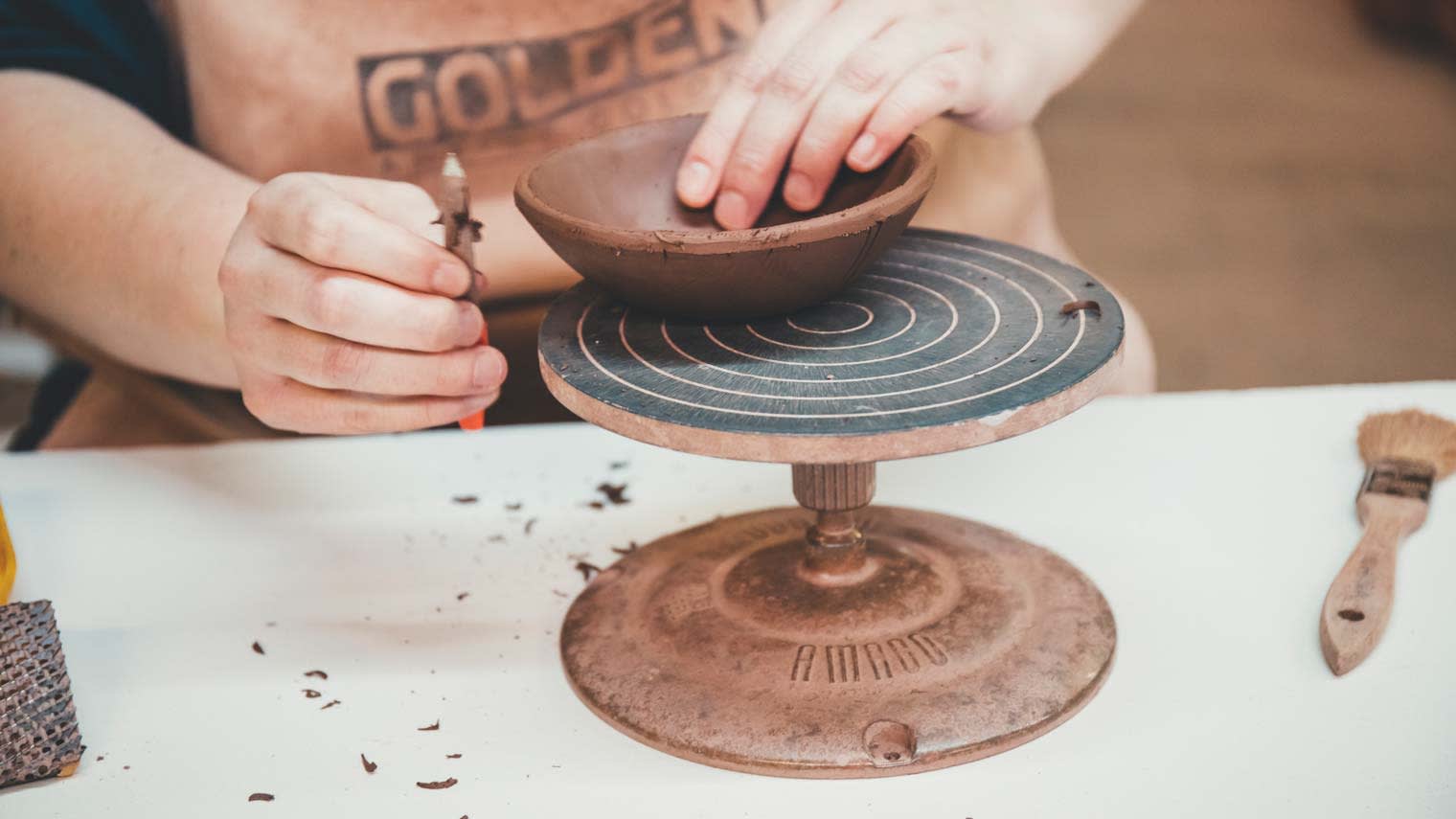 Close up of a ceramics artist at R. Wood studio forming a bowl with their hands.