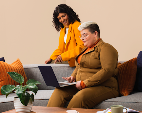 A person showing their co-founder all the progress their business has made since signing up for Mailchimp.