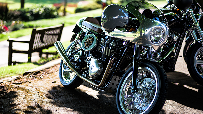 Row of parked motorcycles in dappled sunlight, showing chrome details and classic styling from different angles