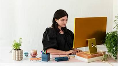 A person in black working at a modern desk with plants, laptop, and office supplies shown in a series of connected images