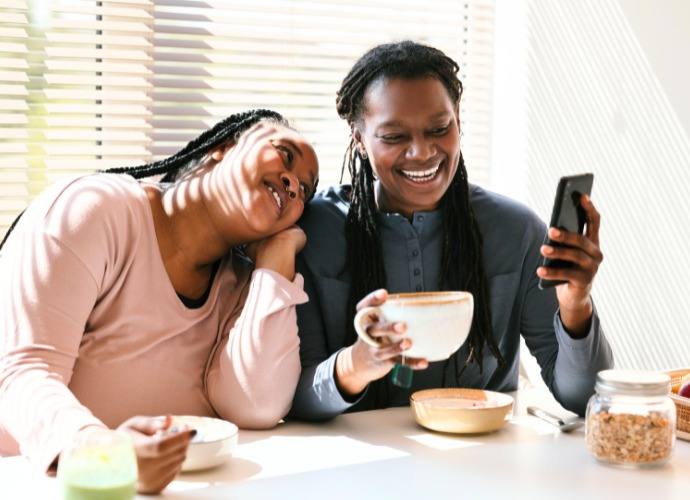 Smiling mother and daughter looking at a smartphone together