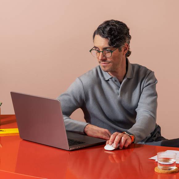 Man in grey shirt working on a red desk