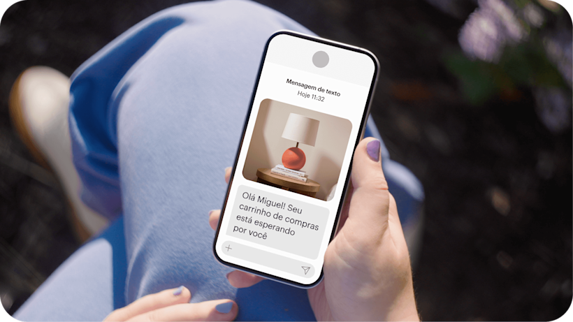 Imagem mostrando uma pessoa segurando um smartphone que exibe uma mensagem de texto da marca fictícia Assembly. O gráfico demonstra como as empresas podem aumentar as vendas com automações de carrinho abandonado e recuperar oportunidades de vendas perdidas.