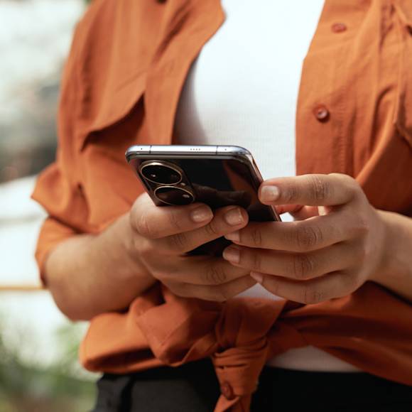Person in orange shirt holding phone