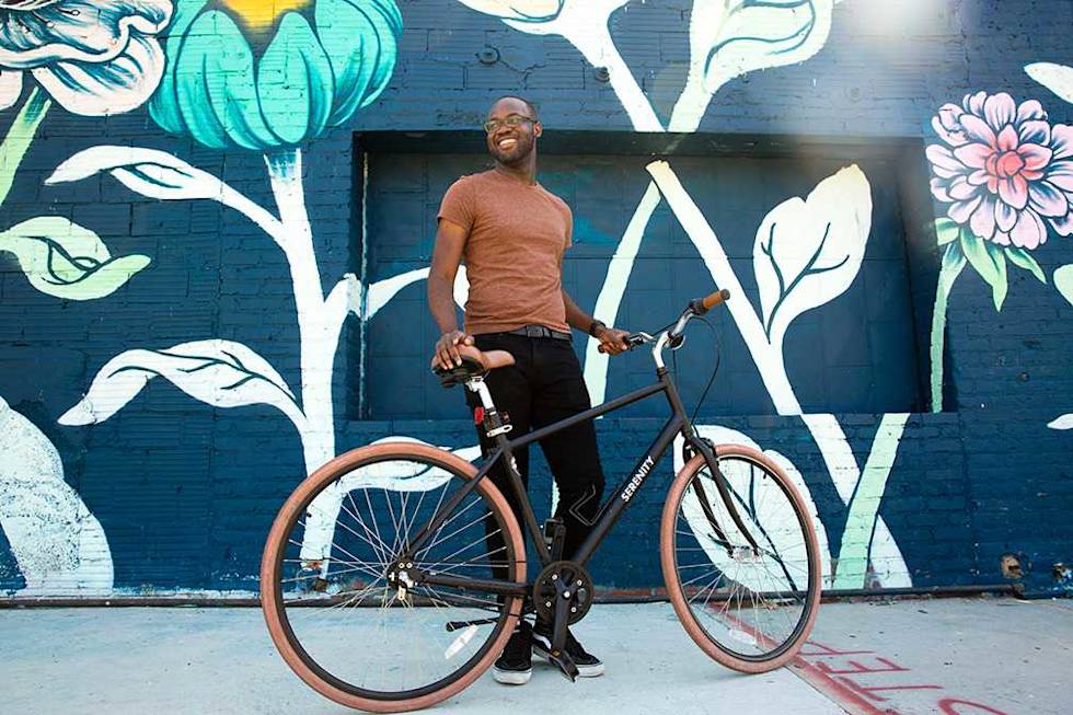 A Mailchimp employee standing with a bicycle