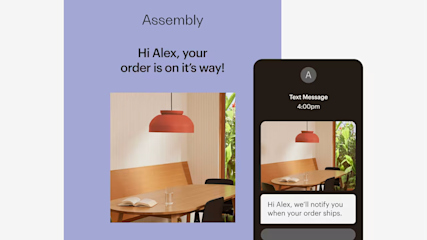 Modern dining area with wooden tables, black chairs, and coral pendant lamps, shown in a text message notification interface