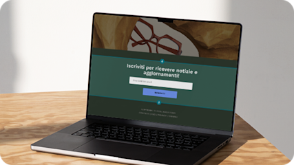 Laptop su un tavolo in legno sul cui schermo viene visualizzato un modulo pop-up di un sito web di e-commerce, che offre ai visitatori l'opportunità di iscriversi alla newsletter del brand fornendo il proprio indirizzo email. 