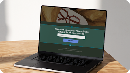 Ordinateur portable sur une table en bois affichant un formulaire contextuel sur un site Web d'e-commerce, offrant aux visiteurs la possibilité de s'inscrire à la lettre d'information de la marque en fournissant leur adresse électronique. 