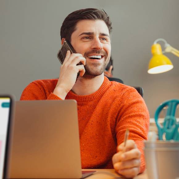 Man in orange sweater, talking on the phone