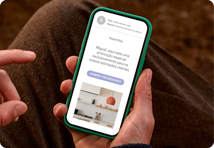 Imagem de uma pessoa olhando para a tela de um smartphone que exibe um e-mail da marca fictícia Assembly. O visual demonstra como os usuários podem personalizar campanhas de marketing com segmentos com base em dados de clientes.