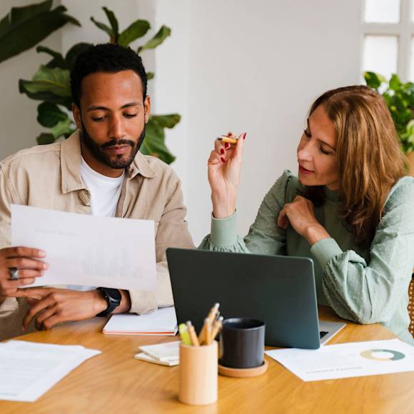 Man and woman collaborating with laptop and chart
