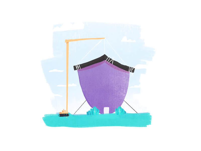 A crane positioning a roof over a house