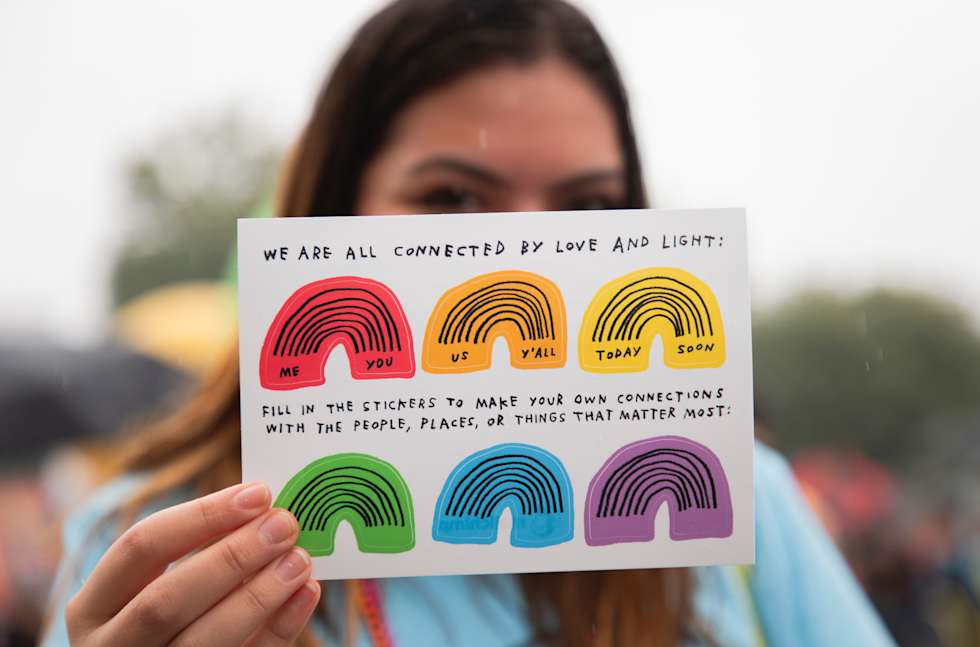 Person walking in Atlanta Pride Parade with Mailchimp shows off awesome stickers designed by Adam Kurtz and the Mailchimp Design Team.
