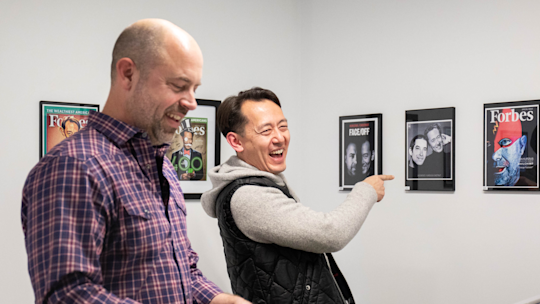 A photograph of Ben and Dan looking at the employee art