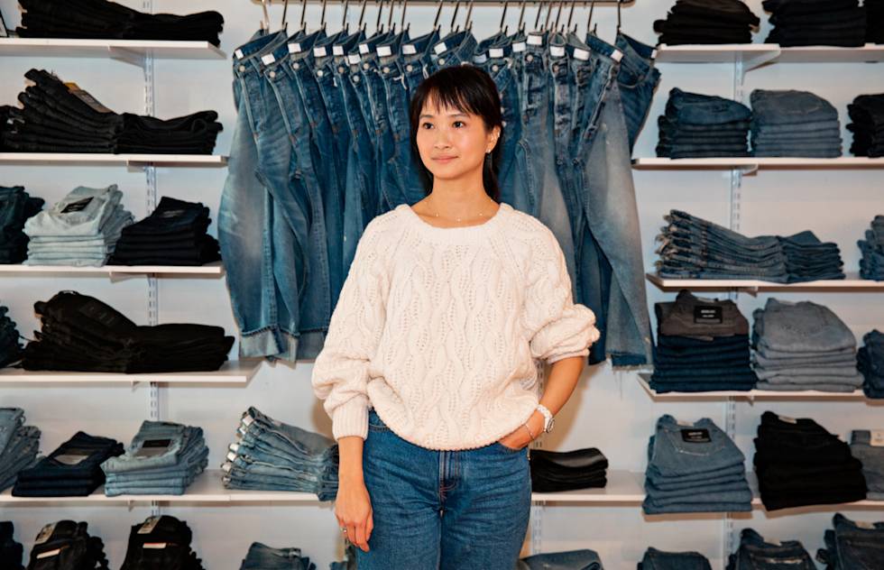 Co-owner of Azalea standing in front of a wall of merchandise.