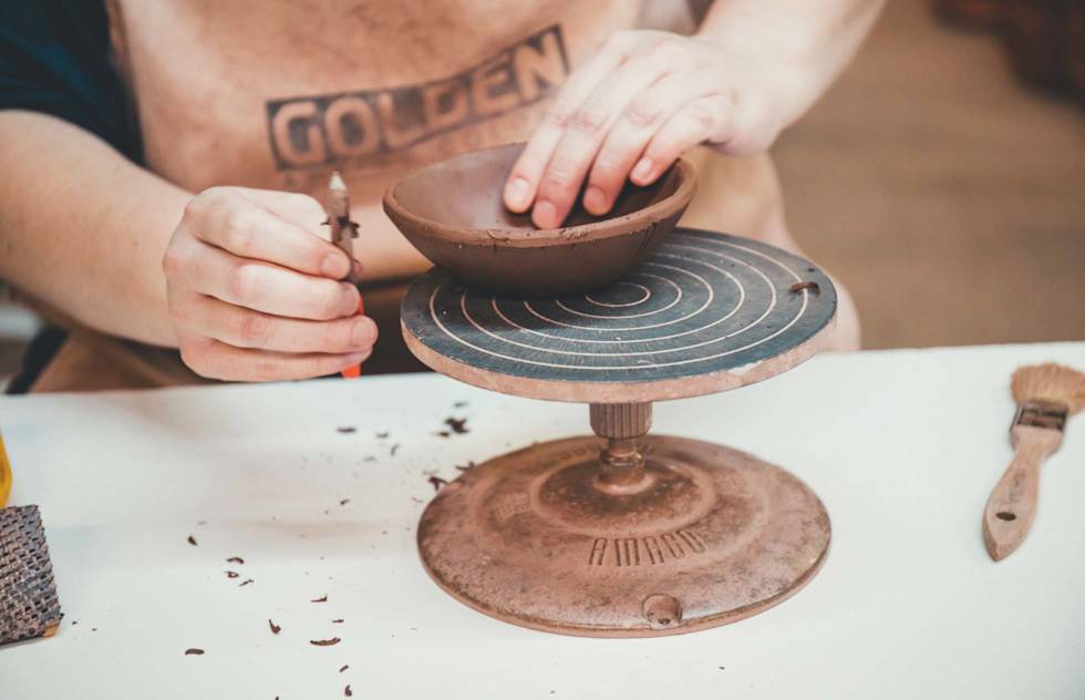 Close up of a ceramics artist at R. Wood studio forming a bowl with their hands.