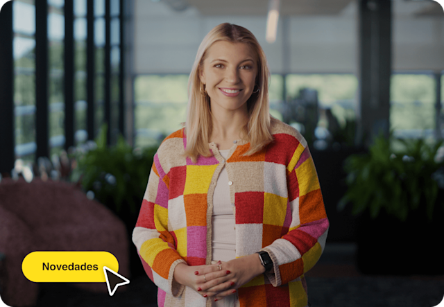 Imagen de una persona de pie y sonriendo con una interfaz de usuario abstracta flotante del cursor y botón de un mouse. La imagen muestra cómo los usuarios pueden explorar las nuevas funciones avanzadas de Mailchimp.