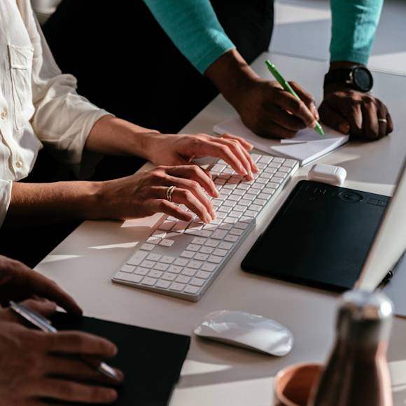 Typing and writing notes on a notepad