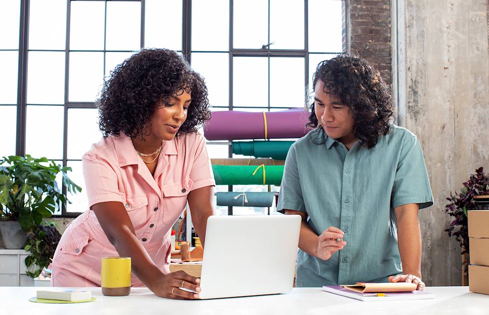 Two people working on shared computer