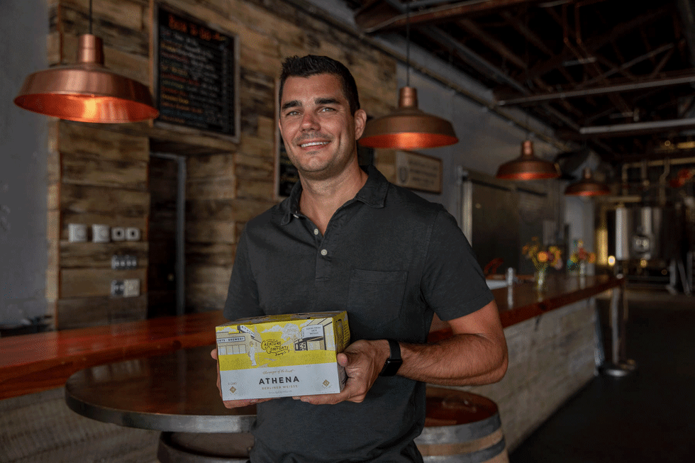 GIF of Chris Herron holding CC beer cases.