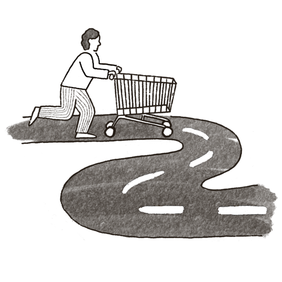 Person pushing a shopping cart down a windy road