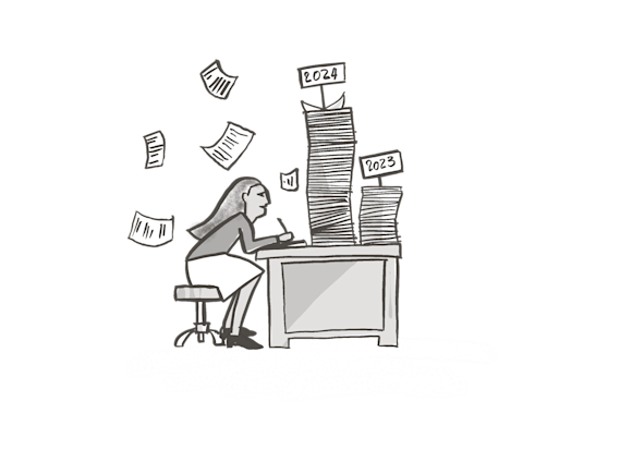 Person working with a stack of papers on desk