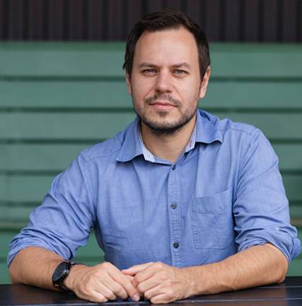 A photograph of Krešimir Končić in a blue shirt sitting at a table.