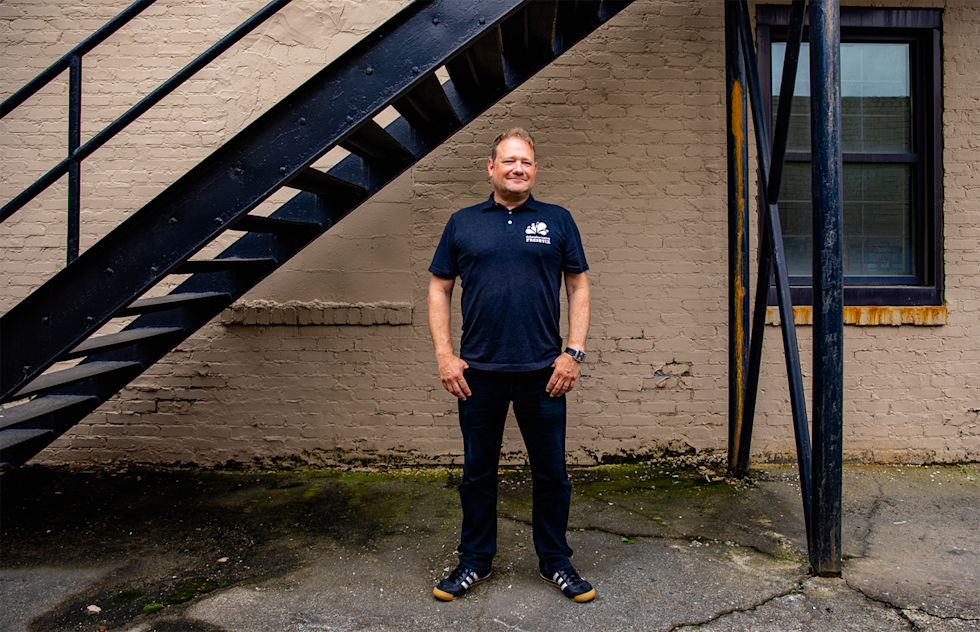 Freshtix Co-founder Iain Bluett standing and smiling outside of the Freshtix office. 
